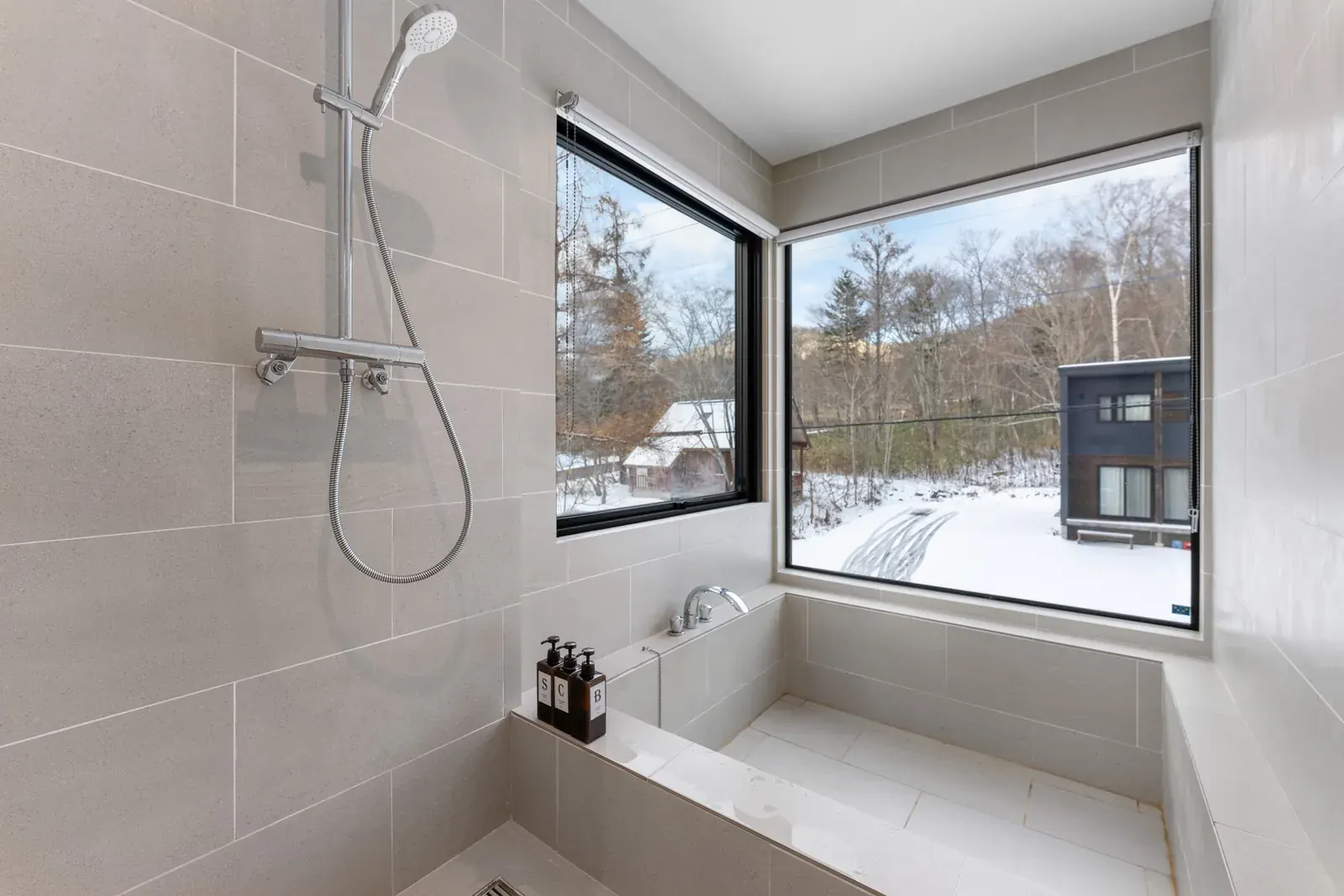 Bathroom with a deep tub and a corner window onto winter snow